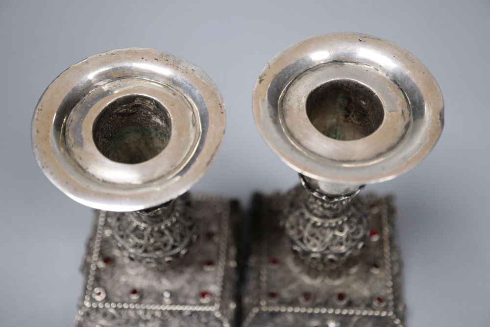 A pair of continental filligree white metal and red stone set dwarf candlesticks (possibly Malta), 11.4cm, weighted.